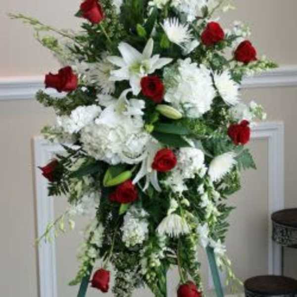 Standing spray of red roses and white lilies on a tripod easel