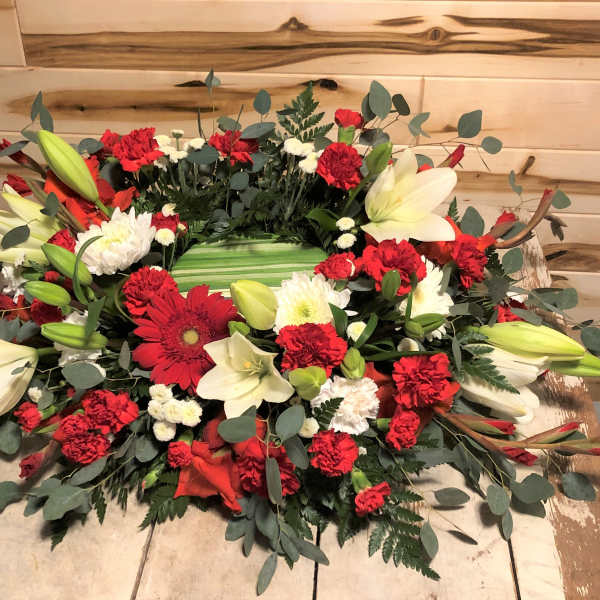 Red and white floral wreath with lilies and carnations
