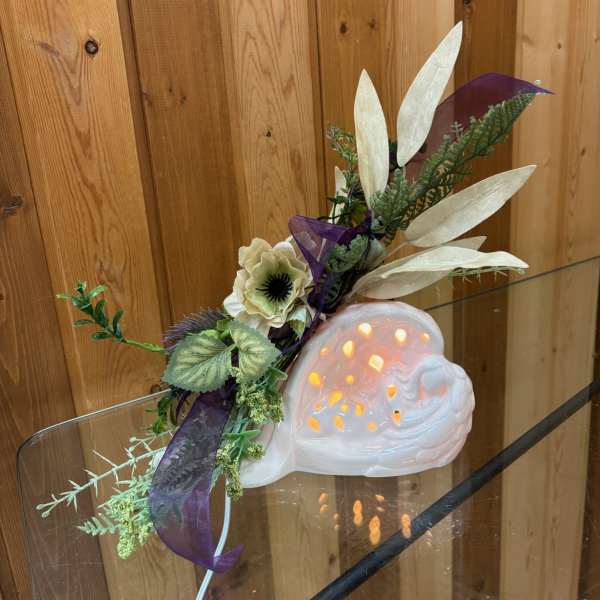 Decorative ceramic snail with a floral accent and purple ribbon