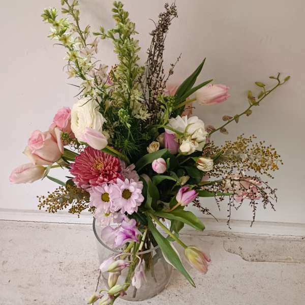 Mixed bouquet of pink and white flowers in a clear glass vase