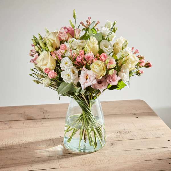 Bouquet of pink and white roses in a clear glass vase