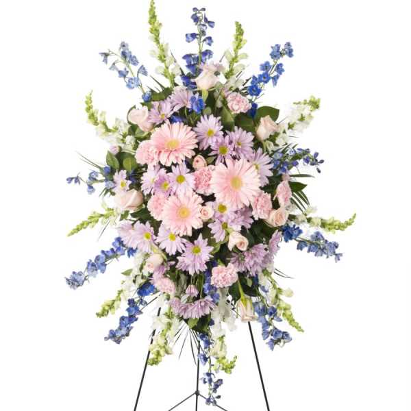Standing floral spray with pink and lavender blooms on a black easel