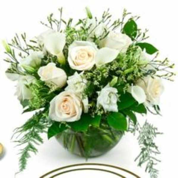 White roses and calla lilies in a glass vase