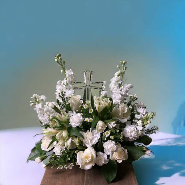 White floral arrangement with a clear glass cross centerpiece