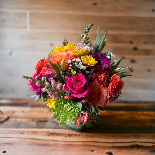 Colorful mixed bouquet with roses, daisies, and snapdragons in a vase