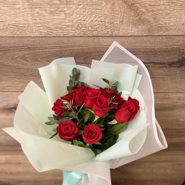 Bouquet of red roses wrapped in white paper
