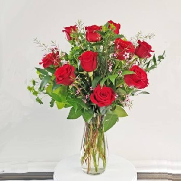 Red roses arranged in a clear glass vase