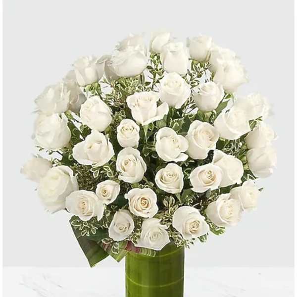 White rose bouquet in a tall green glass vase