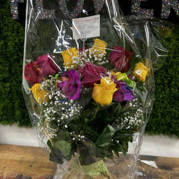 Bouquet of multicolored roses wrapped in clear plastic
