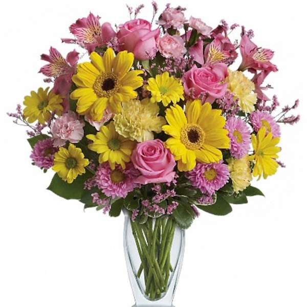 Pink and yellow mixed flower bouquet in a clear glass vase