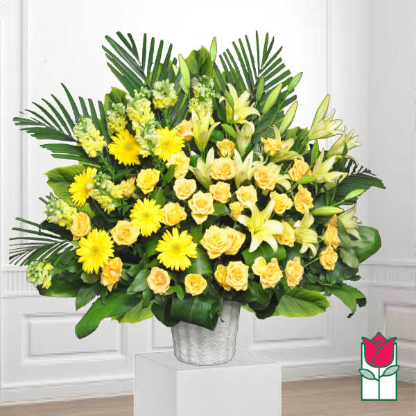 Yellow roses and lilies arranged in a white vase