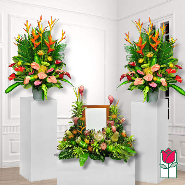 Tropical floral arrangement with orange heliconia and pink anthuriums in a vase