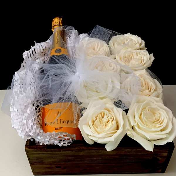 Champagne bottle in a wooden box with white roses and tulle