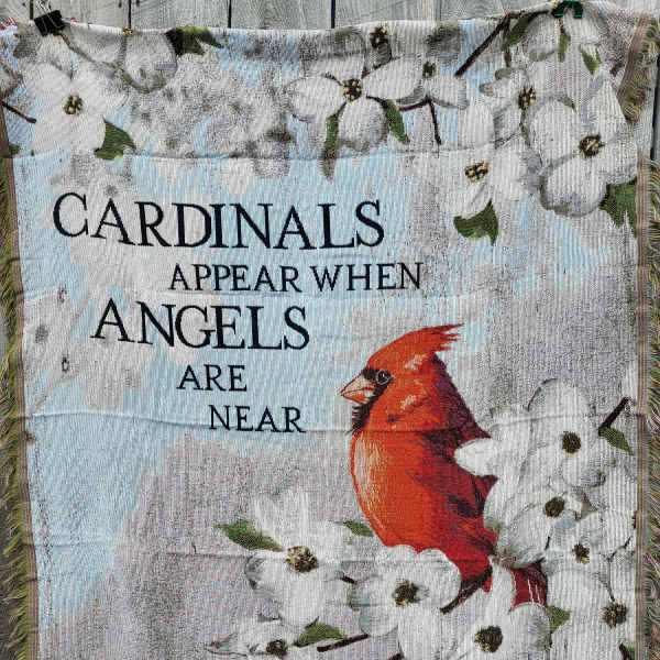 Decorative blanket with white flowers, a red cardinal, and the text "Cardinals appear when angels are near"