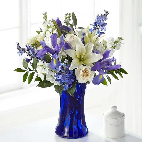 Blue vase holding white and purple flowers