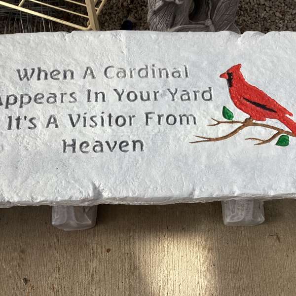White memorial plaque with a red cardinal and engraved text