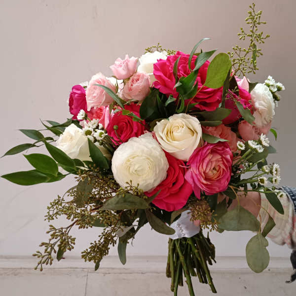 Hand-tied bouquet of pink and white roses with greenery