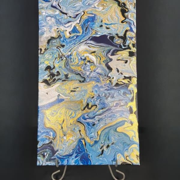 Abstract blue, white, and yellow marbled painting on a stand