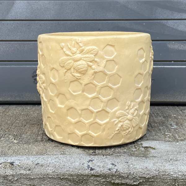 Beige ceramic planter with embossed bees and honeycomb pattern