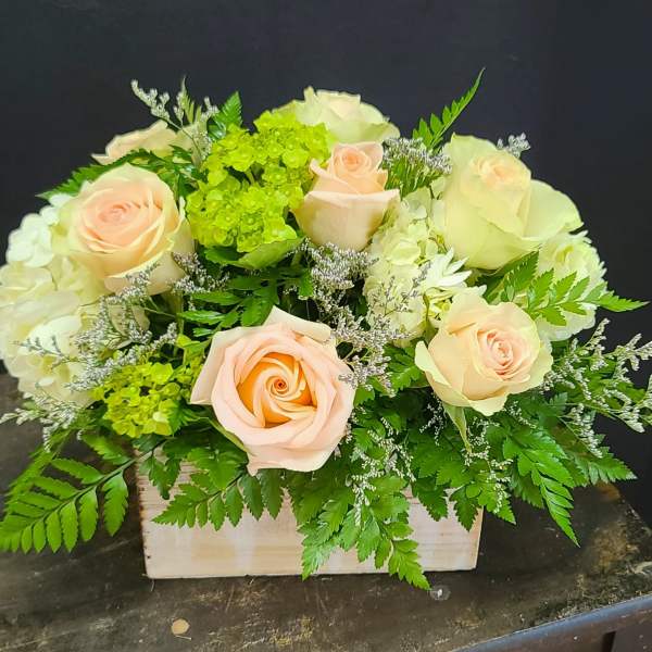 Peach roses and white hydrangeas in a wooden box