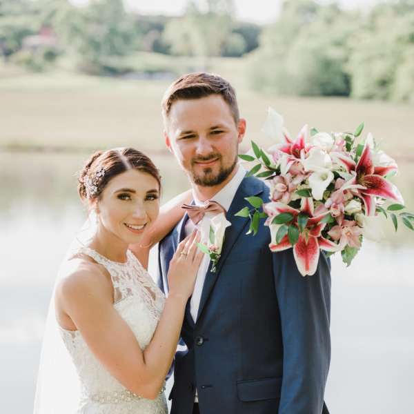 Bride and groom with a pink-and-white wedding bouquet and boutonniere