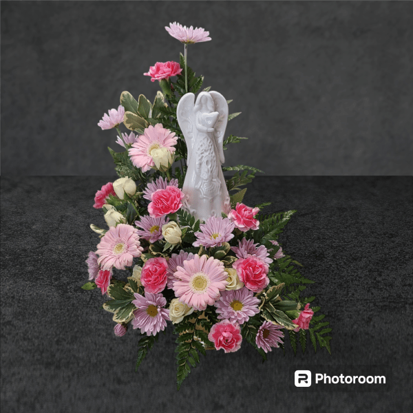 Pink and white floral arrangement with a white angel figurine