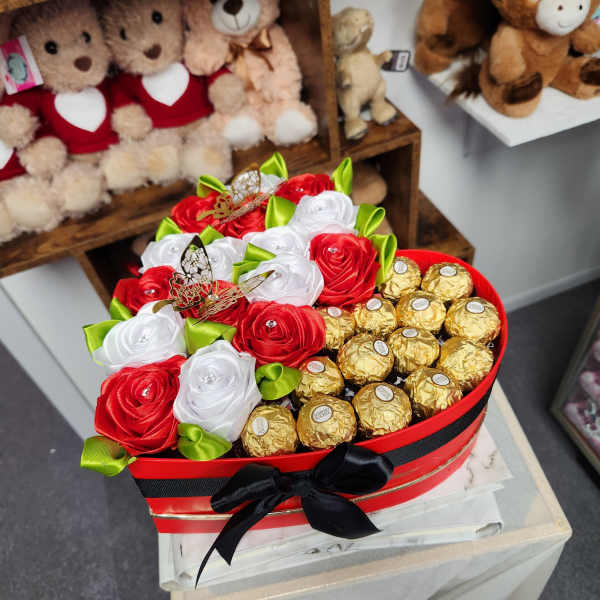 Heart-shaped gift box with ribbon roses and gold-wrapped chocolates