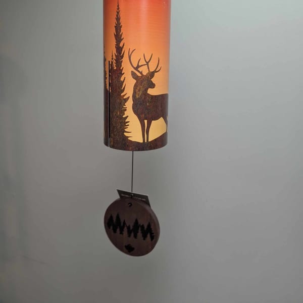 Hanging metal wind chime with a deer and pine tree silhouette