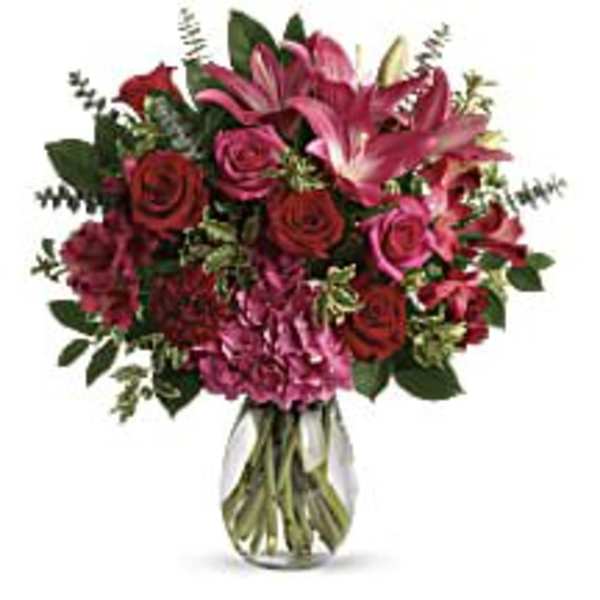 Bouquet of pink lilies, roses, and alstroemeria in a clear glass vase