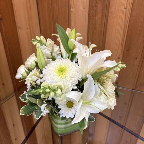 White lilies and chrysanthemums in a green striped vase