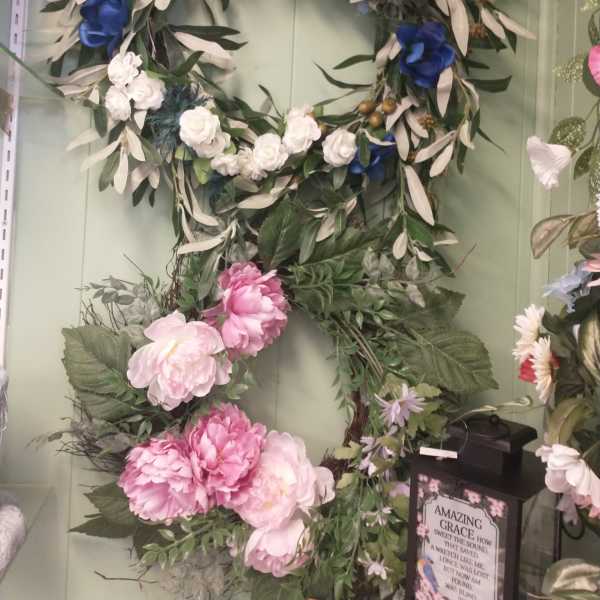 Floral wreath with blue and white flowers on a green wall