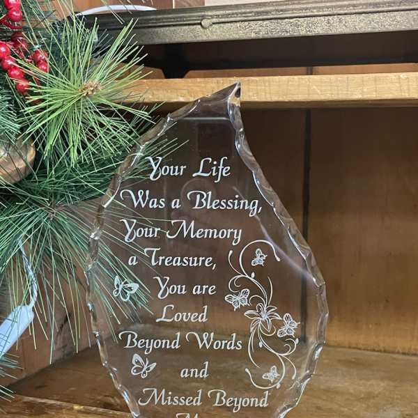 Clear memorial plaque on a black base with engraved sympathy message