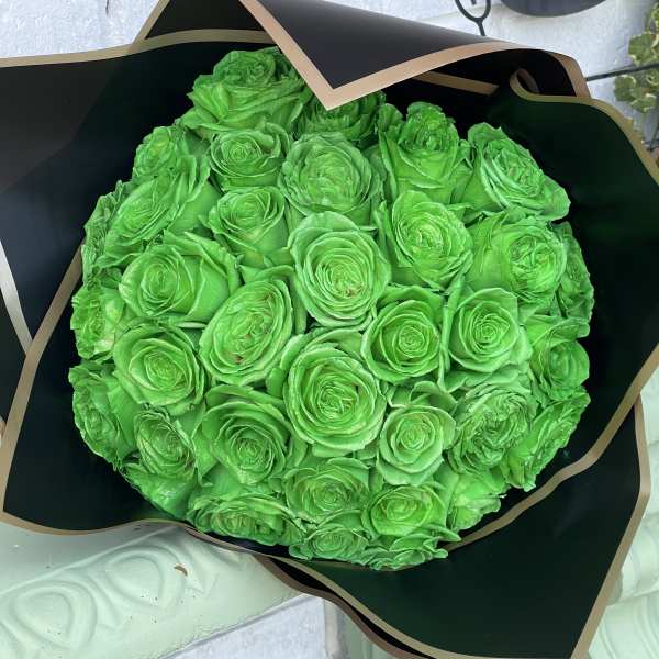 Round bouquet of bright green roses wrapped in black paper