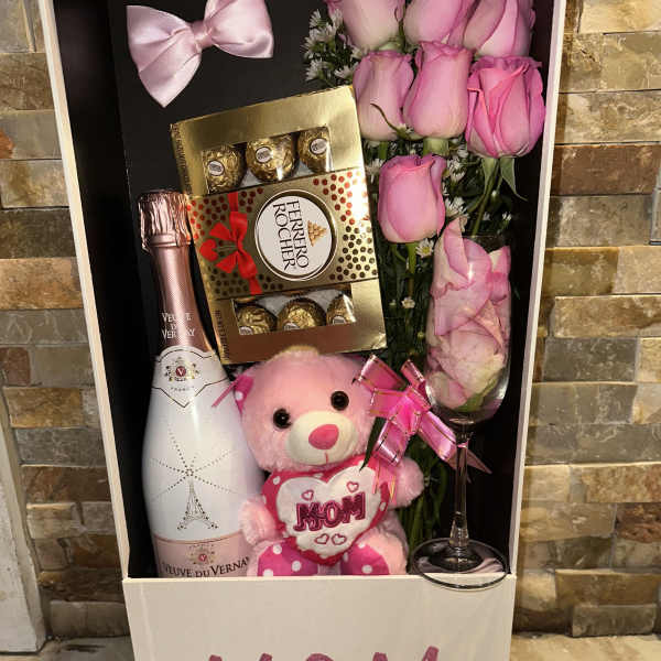 Gift box with pink roses, champagne, chocolates, and a teddy bear labeled MOM