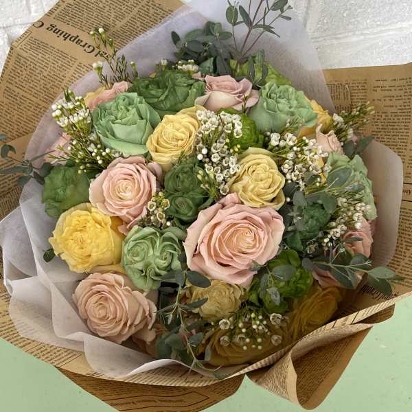 Bouquet of pastel roses wrapped in paper