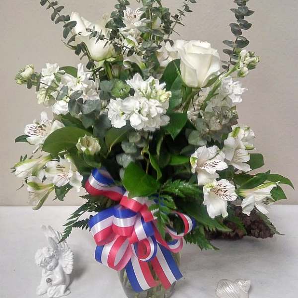 White floral arrangement with roses and alstroemeria in a glass vase