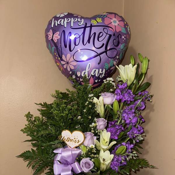 Purple Mother's Day balloon above a lavender floral arrangement in a box