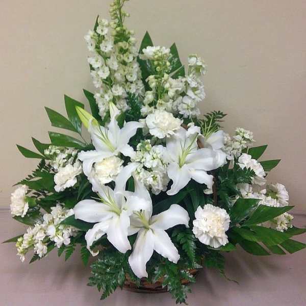 White lilies and carnations arranged in a basket