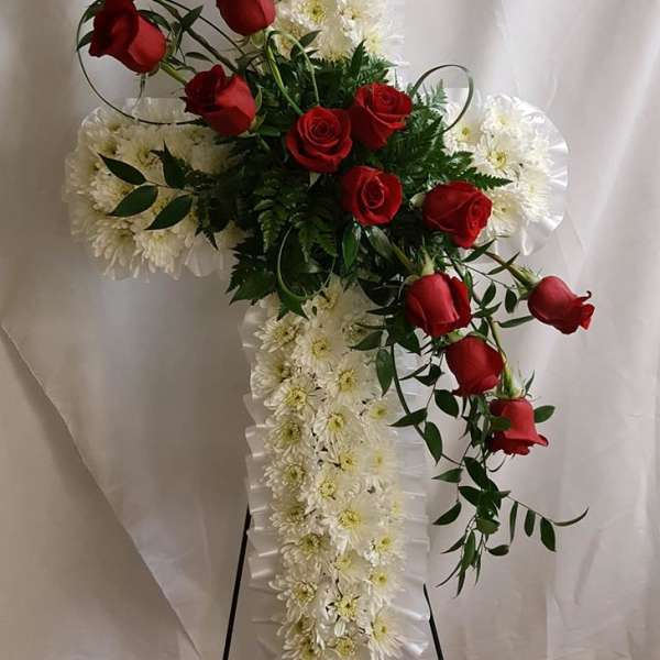 Cross-shaped floral spray with red roses and white daisies