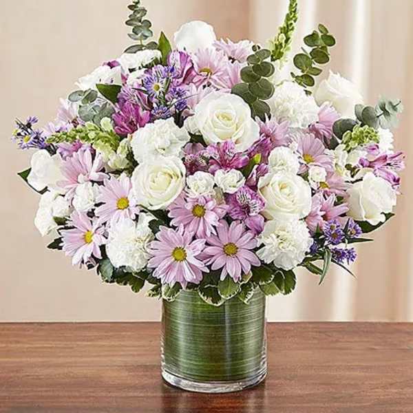 Bouquet of white and lavender flowers in a green glass vase