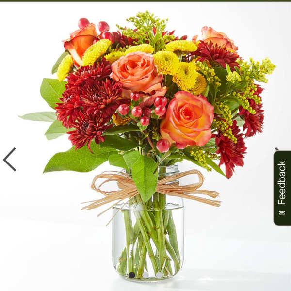 Bouquet of orange roses and red chrysanthemums in a glass vase