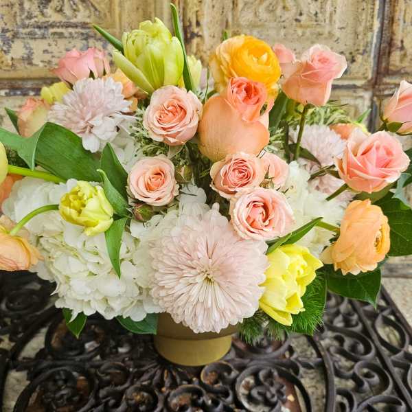 Pastel bouquet of roses, tulips, and chrysanthemums in a low vase