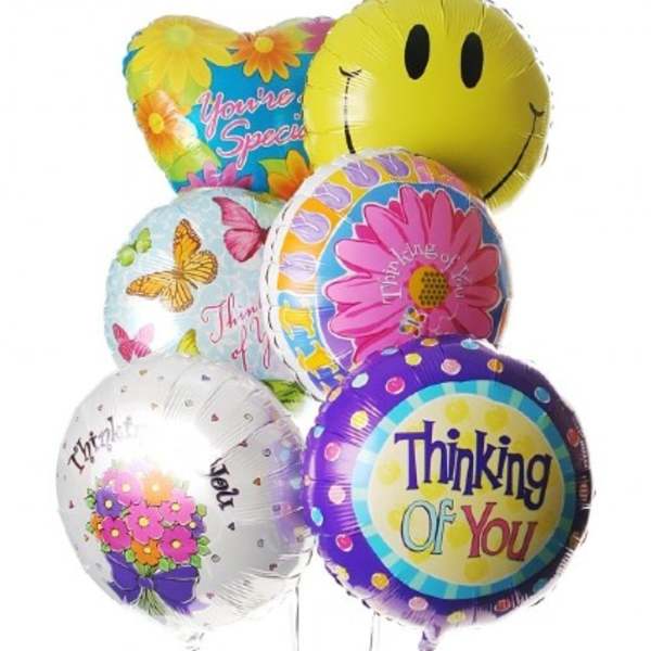 Cluster of colorful foil balloons with smiley and thank-you messages