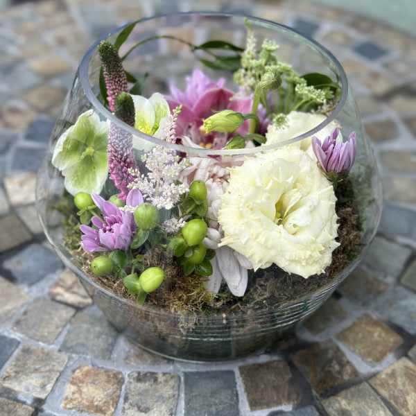 Low glass bowl arrangement with white and pink flowers nestled in moss.