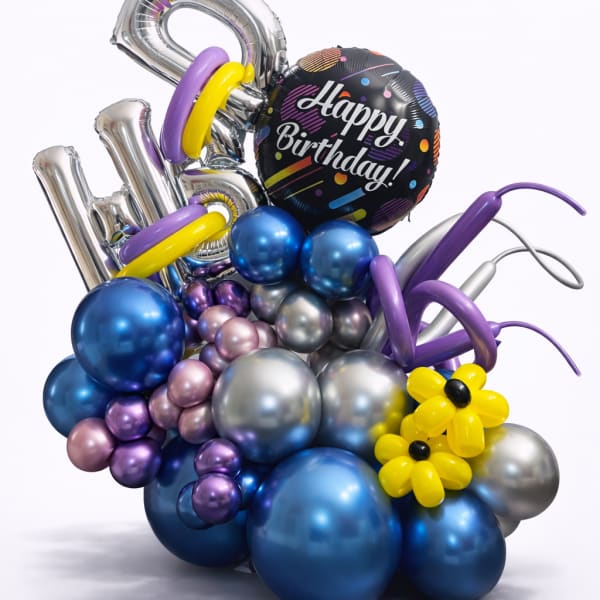 Birthday balloon arrangement with metallic number balloons and a "Happy Birthday" balloon