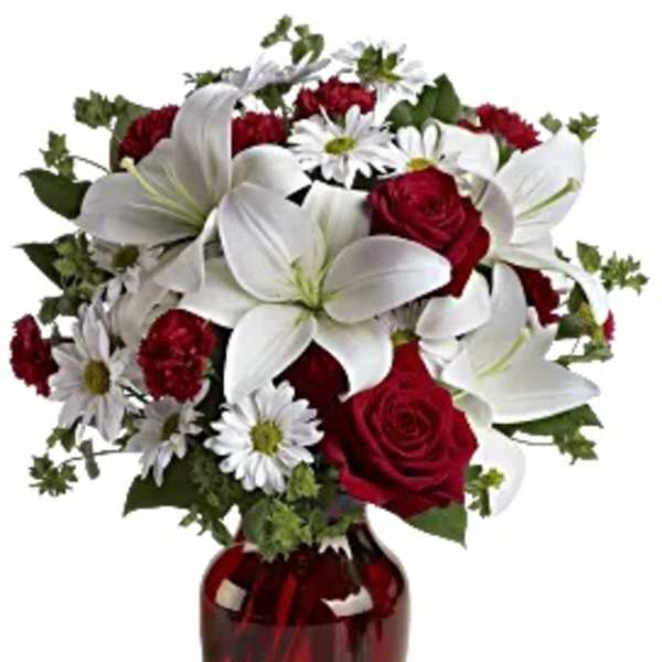 Bouquet of red roses, white lilies, and daisies in a red glass vase