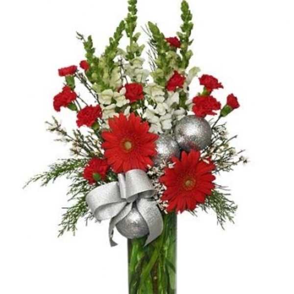 Tall red and white flower arrangement with silver ornaments in a green glass vase
