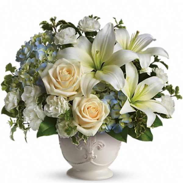 White lilies and cream roses in a decorative vase