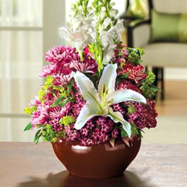 Pink and white floral arrangement in a brown bowl vase