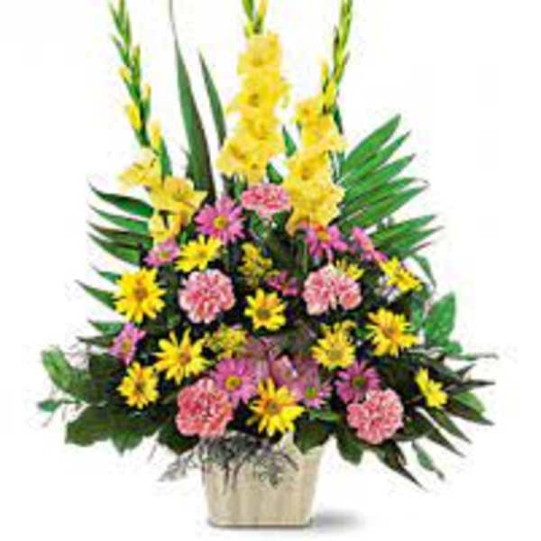 Tall mixed floral arrangement in a square vase with yellow and pink blooms
